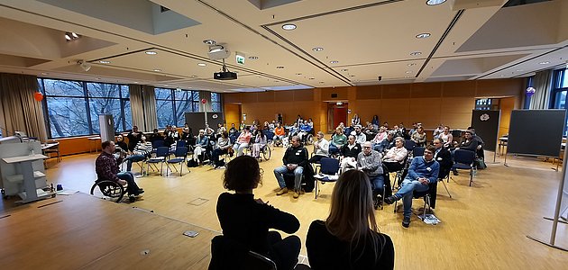 Bild vom letzten Akadmie Forum, bei dem alle Teilnehmer im großen Saal sitzen.